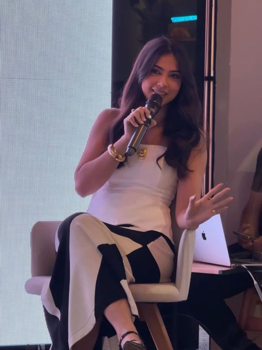 Jordana falando ao microfone durante uma palestra.