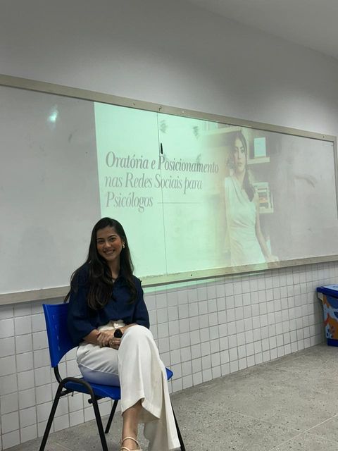 Jordana ministrando aula em uma sala de universidade.