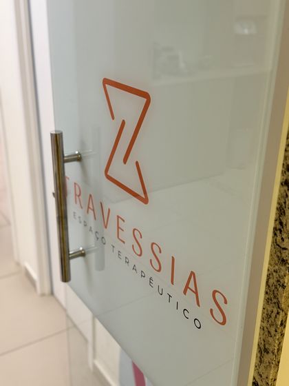 Entrada do Travessias · Espaço Terapêutico, na Av. João da Escóssia, em Mossoró-RN: porta de vidro jateado com a marca do espaço.