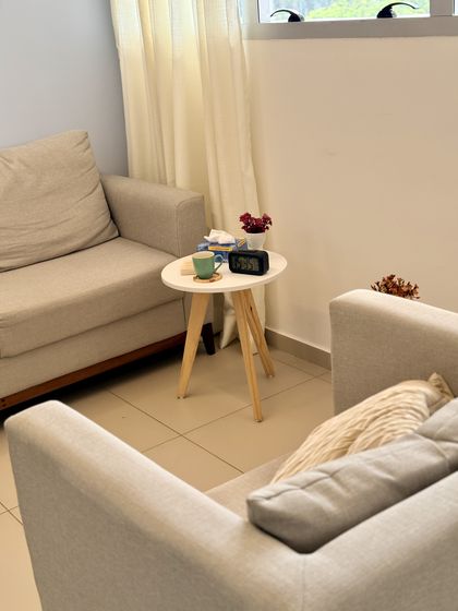 Sala de atendimento com duas poltronas voltadas uma para a outra e mesinha ao centro.